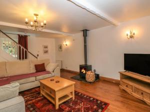 un soggiorno con divano e camino di Monk's Cottage a Buxton