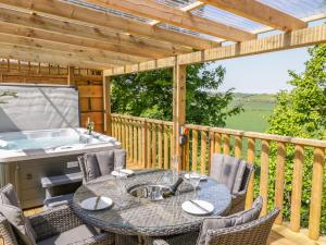 a patio with a table and chairs and a tub at Elm Lodge in Watchet