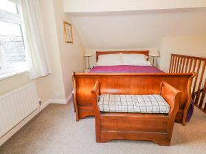 a bedroom with a wooden bed and a window at Kirkstone Cottage in Ambleside