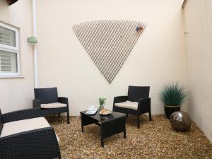 a patio with chairs and a table and a wall at 10 Cove View in Ilfracombe