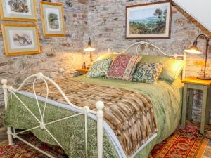 a bedroom with a bed and a stone wall at The Bothy in Callington