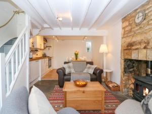 a living room with a couch and a fireplace at Thrower's Cottage in Blockley