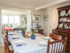 mesa de comedor con mantel azul y blanco en Warren Farmhouse, en Llanwnda