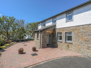 een stenen huis met een stenen oprit bij Bwthyn Alberts in Trearddur