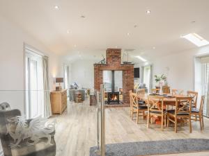 een eetkamer en een woonkamer met een tafel en een open haard bij Bwthyn Alberts in Trearddur