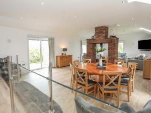 een eetkamer en woonkamer met een tafel en stoelen bij Bwthyn Alberts in Trearddur