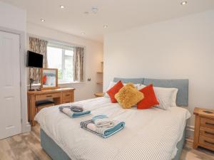 een slaapkamer met een bed met handdoeken erop bij Bwthyn Alberts in Trearddur