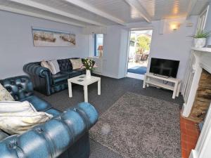 a living room with a couch and a tv at Pebble Cottage in Redruth