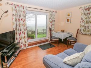 a living room with a couch and a table at Bretton Mount Studio Flat in Eyam