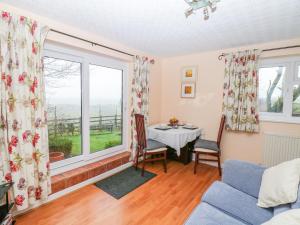 a living room with a table and a large window at Bretton Mount Studio Flat in Eyam