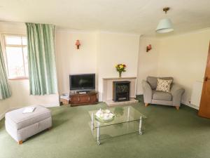 a living room with a fireplace and a television at The Bothy in Eye