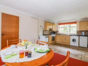 a kitchen with a table and chairs and a dining room at The Bothy in Eye