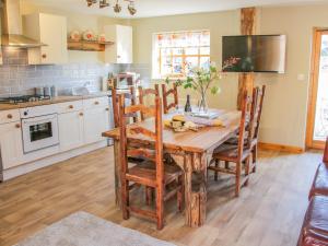 a kitchen with a wooden table and chairs at Old Hall Barn 2 in Church Stretton