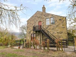 an old stone house with a staircase in front of it at Highview in Keighley