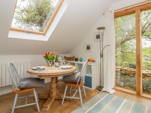 艾維布里奇的住宿－Orchard Loft，一间带木桌和椅子的用餐室