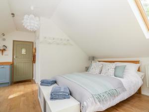 Un dormitorio con una gran cama blanca y una ventana en Orchard Loft, en Ivybridge