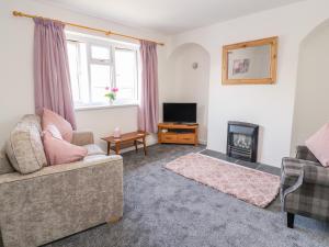 a living room with a couch and a fireplace at 2 Maes Ffynnon in Ruthin