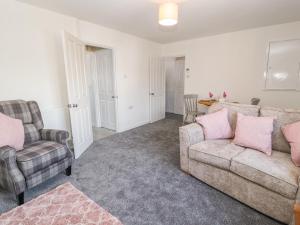 a living room with two chairs and a couch and a table at 2 Maes Ffynnon in Ruthin