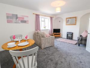 a living room with a table and a couch at 2 Maes Ffynnon in Ruthin
