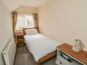 a small bedroom with a bed and a table at Corner Cottage in York