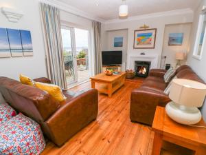 ein Wohnzimmer mit Ledermöbeln und einem Kamin in der Unterkunft Mount View Cottage in Marazion