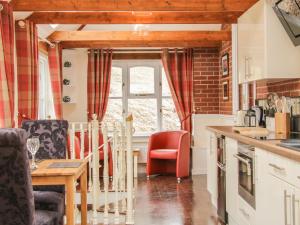 een keuken met rode stoelen en een tafel in een keuken bij Ragleth Place Lodge in Church Stretton