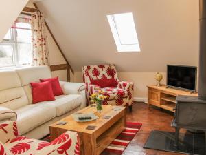 een woonkamer met een bank en een tv bij Ragleth Place Lodge in Church Stretton