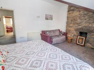 a bedroom with a large bed and a stone fireplace at Tram View in Llandudno