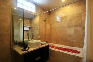 a bathroom with a tub and a sink and a shower at Villa Batu Kurung in Ubud