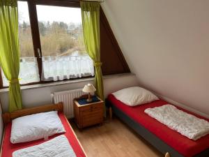 two beds in a small room with a window at Ferienwohnung in Süsel am See in Süsel