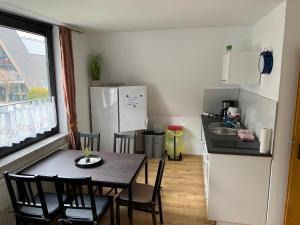 a kitchen with a table and a kitchen with a refrigerator at Ferienwohnung in Süsel am See in Süsel