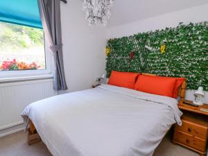 a bedroom with a bed and a green wall at River Cottage in Port Talbot