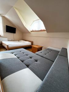 a attic bedroom with two beds and a tv at Guesthouse Smogavc in Zreče +98 photos