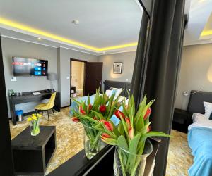 a living room with flowers in a hotel room at Malta Premium in Poznań
