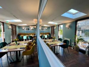 a restaurant with wooden tables and chairs and windows at Malta Premium in Poznań
