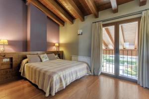 a bedroom with a bed and a large sliding glass door at Mas d'Aravó in Bolvir