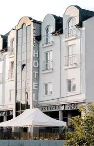 un bâtiment avec un parasol blanc devant lui dans l'établissement Baltic Hotel, à Gdynia