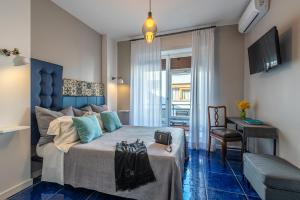 a bedroom with a large bed with a blue headboard at B&B il Duca d'Amalfi in Salerno