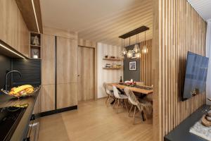 Savoy Exclusive Mountain Apartment في سبيندلروف ملين: مطبخ وغرفة طعام مع طاولة وكراسي