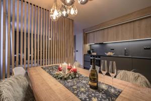 un comedor con una mesa con botellas de vino y copas en Savoy Exclusive Mountain Apartment, en Špindlerův Mlýn