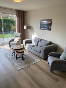 ein Wohnzimmer mit einem Sofa, einem Tisch und Stühlen in der Unterkunft House in a quiet location in Zeeland 2 in Bruinisse