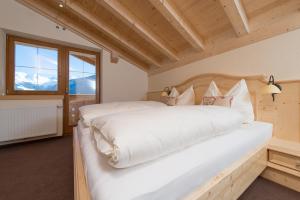 a bedroom with a large white bed and a window at Apart Krismer in Ladis
