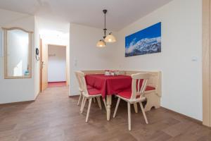 a dining room with a red table and chairs at Apart Krismer in Ladis