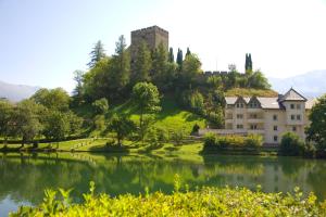 a castle on top of a hill next to a lake at Apart Krismer in Ladis