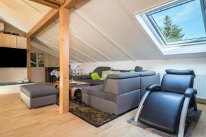 a living room with a vaulted ceiling with a skylight at Luxuriöses Penthouse-appartement in Höchst