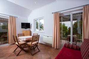 ein Wohnzimmer mit einem Tisch, Stühlen und einem TV in der Unterkunft Apartments Benussi in Dubrovnik