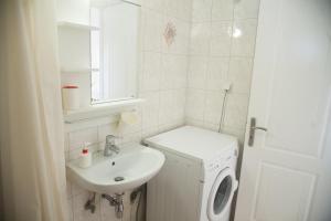 a bathroom with a sink and a washing machine at K Downtown Lefkada studios & apartments in Lefkada