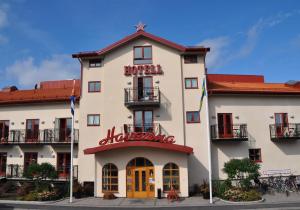 a large white building with a red sign on it at Hotell Havanna in Varberg