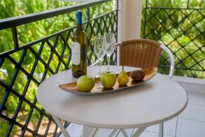 a plate of apples and a bottle of wine on a table at K Downtown Lefkada studios & apartments in Lefkada