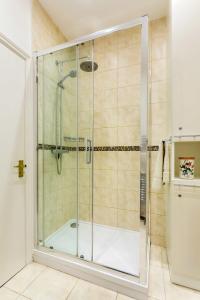 a shower with a glass door in a bathroom at Veeve - Charming Hampstead Apartment in London +12 photos